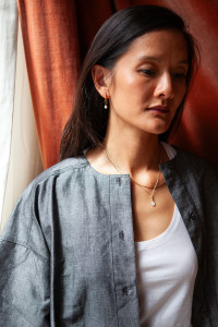 Chaîne en maille fine, dans un style forçat avec un pendentif de forme ovale, monté sur un anneau et un cabochon en nacre.